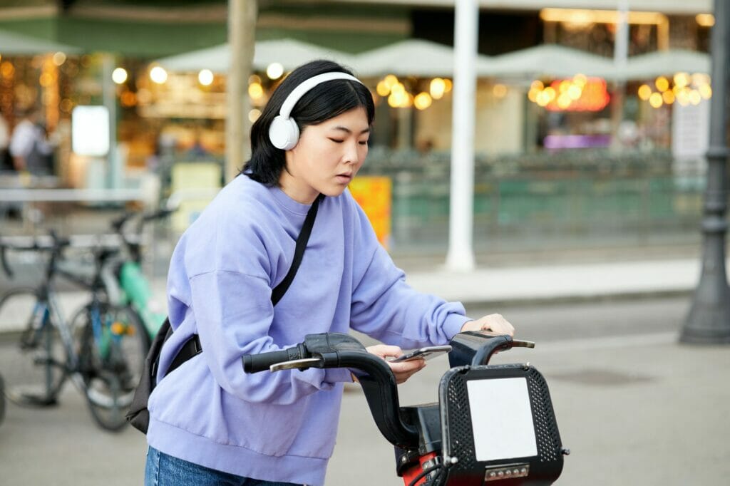 Young Asian woman renting a city bike.